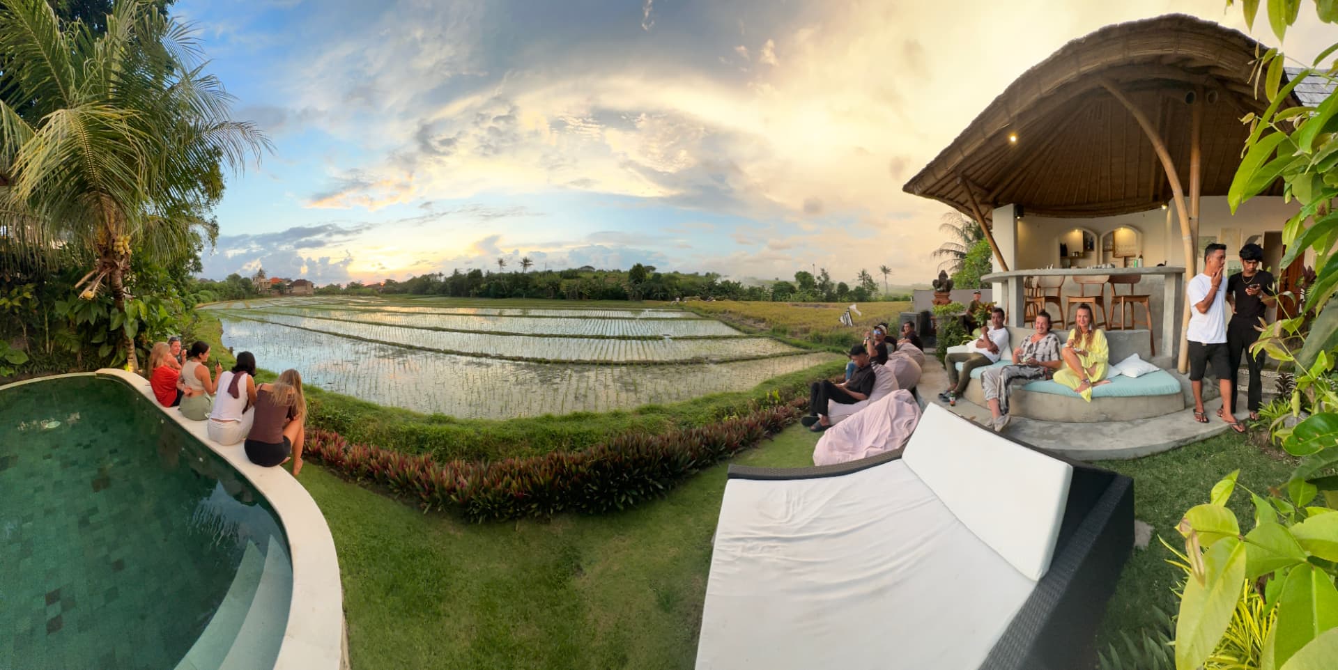 A group gathered in Bali at sunset, overlooking rice fields, ready to play Leela